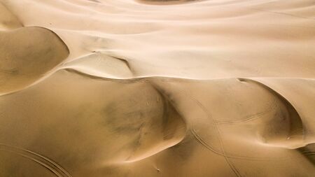 Aerial top-down view of sand dunes. Sand dunes create abstract shapes during the day light. Wind formations.の写真素材