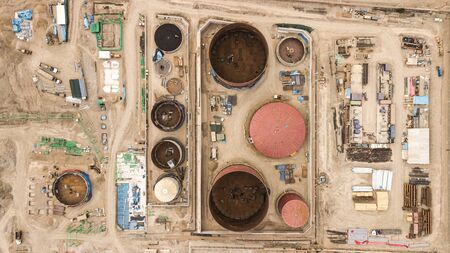 Aerial top down view on petroleum industrial factory, barrels, pipes, equipment parts at the sandy terrain creating an abstract forms and background.の写真素材