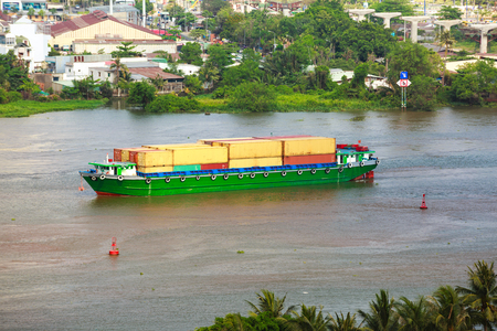 Cargo container ship - freighter navigating riverの写真素材