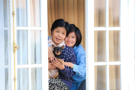 Da Lat Vietnam 10 months 2. 2015: Mother daughter and puppy chihuahua with happy face at the windowのeditorial素材