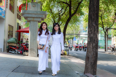 Hochiminh City Vietnam February 16: unidentified Vietnamese Ao dai girls wearing white on the street on February 16 2014. Ao dai is famous traditional for women in Vietnam Custume.のeditorial素材