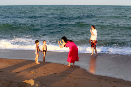 Nha Trang city Vietnam January 27 2014: Unknown a couple and two small sons Frolic in the waves on the tropical coast of Nha Trangのeditorial素材