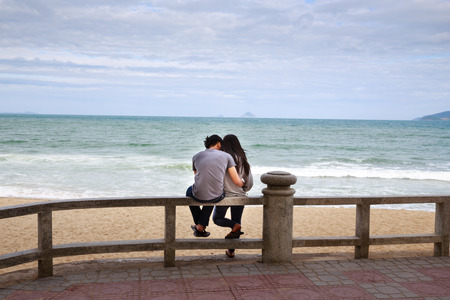 Nha Trang city Vietnam January 27 2014: Unknown confided a young couple sitting together looking very happy seafrontのeditorial素材