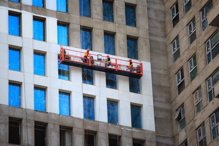 Viet Nam Ho Chi Minh city April 10 2015 Three Workers are built on scaffolding with protective safety equipmentのeditorial素材