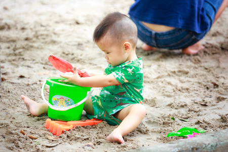 Hochiminh City, Vietnam - June 21, 2015: unidentified, cute baby in a park playing sand alone in Ho Chi Minh City, Vietnamのeditorial素材