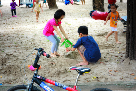 Hochiminh City, Vietnam - June 21, 2015: unidentified, two cute baby in a park playing sand alone in Ho Chi Minh City, Vietnamのeditorial素材