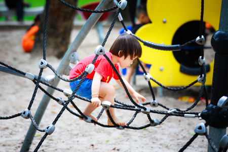 Ho Chi Minh City, Vietnam - June 21, 2015: unidentified, cute girl playing in a park alone tightrope in Ho Chi Minh City, Vietnamのeditorial素材