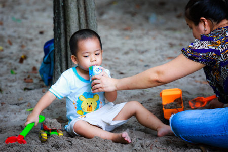 Hochiminh City, Vietnam - June 21, 2015: unidentified, cute baby in a park playing sand alone in Ho Chi Minh City, Vietnamのeditorial素材