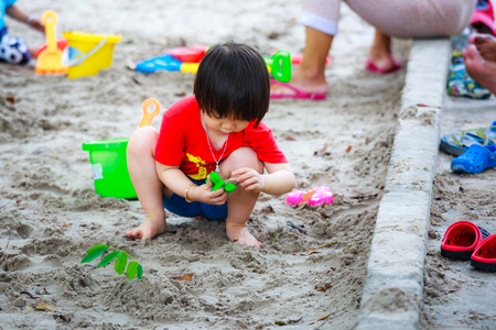 Hochiminh City, Vietnam - June 21, 2015: unidentified, cute girl in a park playing sand alone in Ho Chi Minh City, Vietnamのeditorial素材