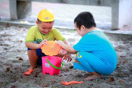 Hochiminh City, Vietnam - June 21, 2015: Unknown, two cute little boys playing in the sand at the city park HoChiMinh, Vietnamのeditorial素材