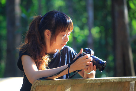 Dong Nai, Vietnam - July 26, 2015: young girls with camera are Discovering morning sun rays on hairのeditorial素材