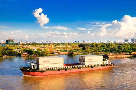 Hochiminh City, Vietnam - August 2, 2015: Maritime transport on river, container loading vessel on water, residential and apartment at riverside, scene of industrial city, Vietnam, August 2, 2015のeditorial素材