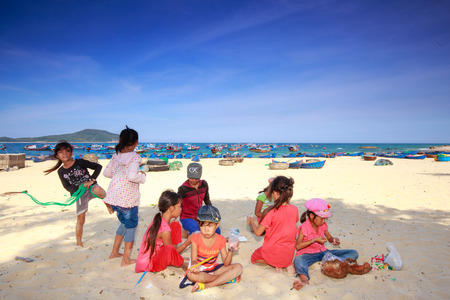 Phuyen province, Vietnam - August 16, 2015: Unknown children playing together of a fishing village on the beach, while parents are working at sea chngのeditorial素材