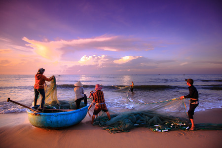 Beach Lagi, Binh Thuan province, Vietnam - August 29, 2015: Unknown Fishermen who pull up th are the fishing nets khi sunrise. This is ask for their daily workのeditorial素材