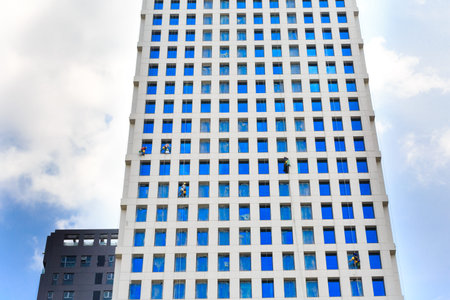 Hochiminh City, Vietnam - September 19, 2015: Dangerous job of the workers cleaning the glass surface m of a new building completedのeditorial素材