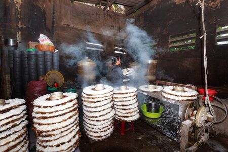 Binh Thuan province, Vietnam - October 12, 2015 at a small factory, where produces rice noodle, the woman Brings basket full of noodles print to the steamer. This is a hard work to make a very tasty traditional Vietnamese dishのeditorial素材