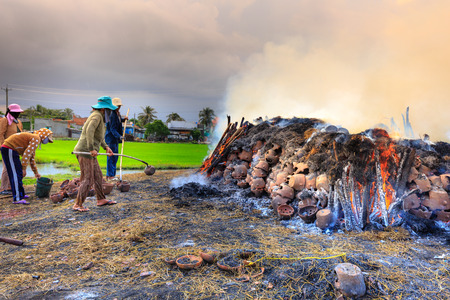 Binh Thuan province, Vietnam - October 12, 2015 at Binh Duc traditional pottery village, the handicraftsmen burn products, ask for c m made by hands in the traditional way with wood and rice straw outdoorsのeditorial素材