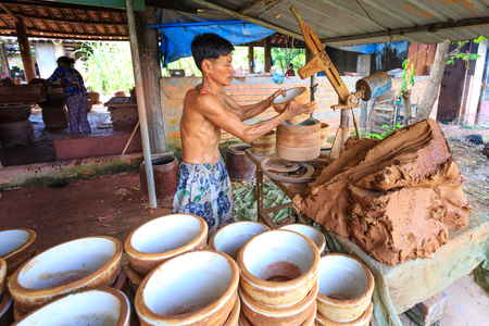 Binh Duong province, Vietnam - October 25, 2015: workers working in ceramics production base. They used clay shaped by hand out of flower pots chngのeditorial素材