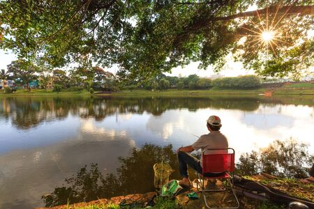 Bao Loc town, Vietnam - October 28, 2015: a man relaxing by the lake is fishing. Recreational Fishing is a pastime of the peoples in the town of Bao Loc.のeditorial素材