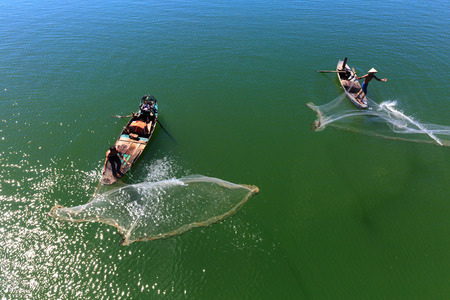 Tri An lake, Dong Nai Province, Vietnam - November 19, 2015: Two men cast fishing nets chng reservoir on the Tri An. This is the daily work of ngi from fishing villageのeditorial素材