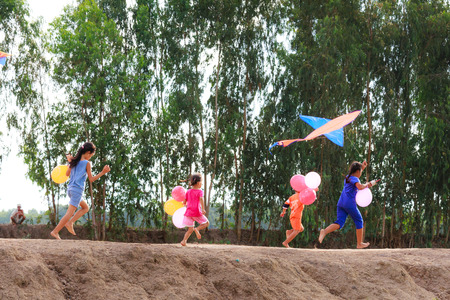 Moc Hoa District, Long An Province, Vietnam - November 22, 2015: in the weekend, children play kites often Do print rural Villages rice paddies together Beside theのeditorial素材