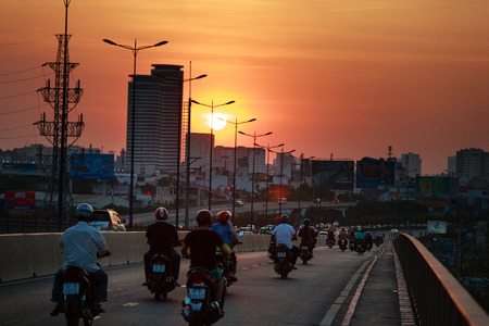 HoChiMinh city, Vietnam - February 7, 2016 : motorbikes traffic on the SaiGon bridge in Hochiminh on the sunset. Saigon is the largest city in Vietnamのeditorial素材