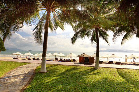 Nha Trang city, Vietnam - February 1, 2016 : Nha Trang beach is breathtaking with beautiful stretched sandy beach, coconut trees, parasols and blue skyのeditorial素材