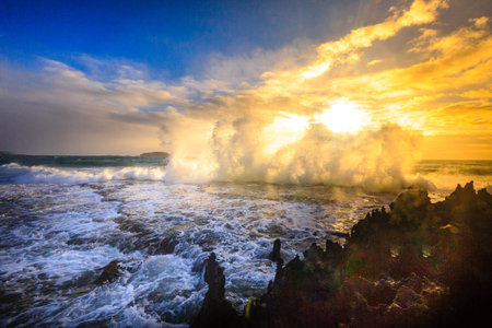 Amazing power of waves crashing against the rocks at dawnの写真素材