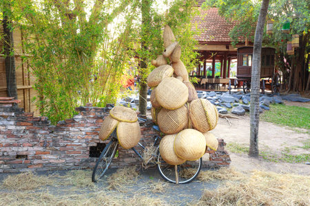 Weaving bamboo products on bicycle to sell on street.  those tools are used in kitchen and catch fish is traditional occupation of Vietnam farmersの写真素材