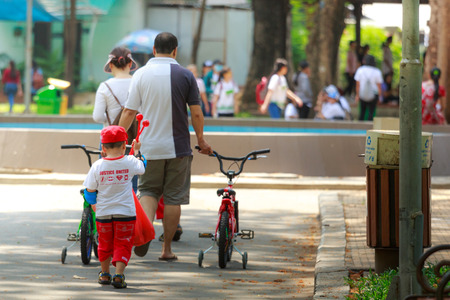 Ho Chi Minh City, Vietnam - March 13, 2016: A father and  his son after a cycling workout in a park in the HoChiMinh cityのeditorial素材