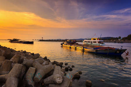 Phu Quoc island, Kien Giang province, Vietnam - May 02, 2016: amazing sunset at breakwater pier on Phu Quoc island . scene the boats were operating on the river to prepare to the sea in the sunsetのeditorial素材