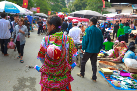Hoang Su Phi, Ha Giang Province, Vietnam October 2, 2016 :  picture of ethnic minority woman carrying a small child on her back at the sunday village fair in Hoang Su Phi, Ha Giang province, Vietnamのeditorial素材