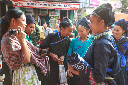Hoang Su Phi, Ha Giang province, Vietnam - October 2, 2016 : a friendly conversation between a traveler with her pet chihuahua dog and ethnic minority people at the sunday village fair in Hoang Su Phi, Ha Giang, Vietnamのeditorial素材