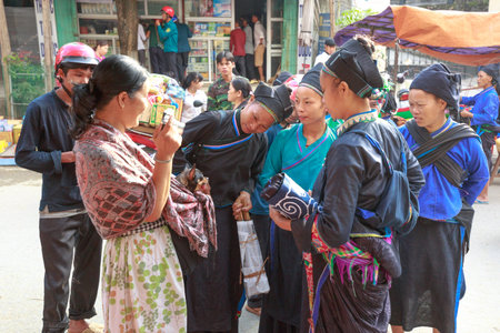Hoang Su Phi, Ha Giang province, Vietnam - October 2, 2016 : a friendly conversation between a traveler and her pet chihuahua dog with ethnic minority people at the sunday village fair in Hoang Su Phi, Ha Giang, Vietnamのeditorial素材