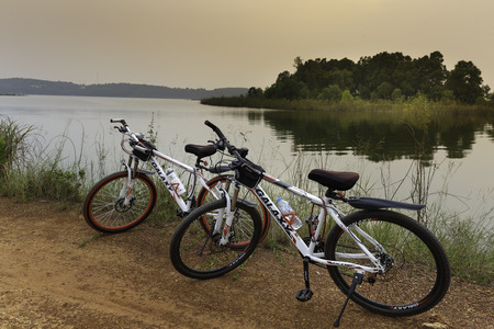 Flamingo Dai Lai, Vinh Phuc, Vietnam - October 10, 2016: Two bicycles beside the lake at sunsetのeditorial素材