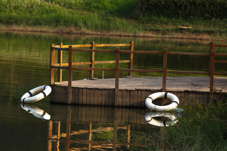 old wooden jetty with life bouy on a lake