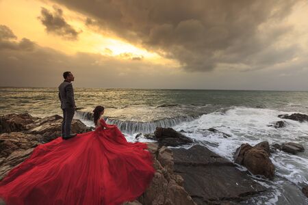 Phan Rang city, Viet Nam - December 25, 2016 : bride and groom on the beach with dramatic cloudy sky and the sea big wavesのeditorial素材