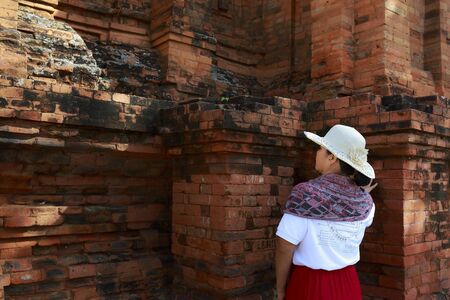 Cham tower, Phan Rang city, Viet Nam - December 25, 2016: a female tourist beside ancient wall of Cham towerのeditorial素材