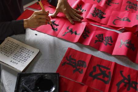 Vung Tau city, Vietnam - December 11, 2016: A scholar writes Chinese calligraphy characters at Long Son, Vung Tau city. Calligraphy giving is a tradition popular for Tet holiday to Vietnamese People.のeditorial素材