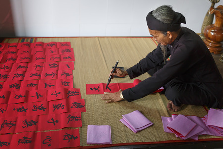 Vung Tau city, Vietnam - December 11, 2016: A scholar writes Chinese calligraphy characters at Long Son, Vung Tau city. Calligraphy giving is a tradition popular for Tet holiday to Vietnamese People.のeditorial素材