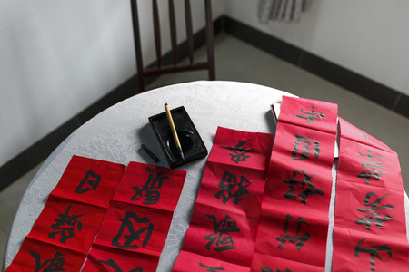 Chinese calligraphy with tools on red background.の写真素材