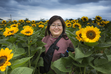 Lam Dong province, Viet Nam - February 19, 2017: Image of a beautiful Asian woman smiling happily with the new blooming sunflowerのeditorial素材
