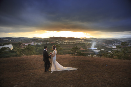 Da Lat town, Vietnam - February 18, 2017: Image of bride and groom photographic memories on the hill at sunset in Dalat town, Viet Namのeditorial素材