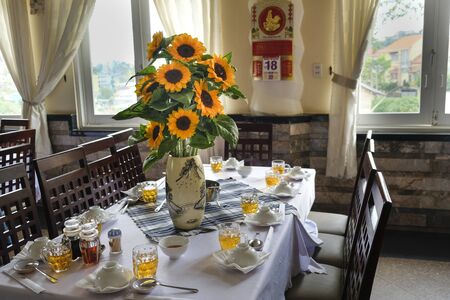 Da Lat town, Viet Nam - February 19th, 2017: beautiful sunflower vase is decorated on the dining table of a restaurant in the Dalat town, Vietnamのeditorial素材