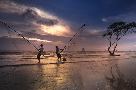 Tan Thanh beach, Go Cong district, Tien Giang province, Vietnam - March 19, 2017: Image of fishing village people using homemade tools to catch fish in sea at sunriseのeditorial素材