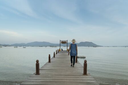 Song Cau town, Phu Yen Province, Vietnam - March 1, 2018: The woman on the wooden fishing pier with beautiful tropical sea view during sunset, Song Cau town in Phu Yen, Vietnamのeditorial素材
