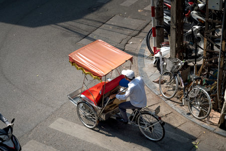 Hanoi capital, Vietnam - July 12, 2018: Cyclo or pedicab driver on Hanoi street. Cyclo is one of the...