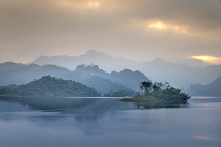 Fantastic clouds and sunset sky. Peaceful time. Colorful sky reflecting in the lake. Silhouette. Summer is coming. Beautiful peaceful scenery of mountain forest in Th.Lam Commune, T. Quang Province,VNの写真素材