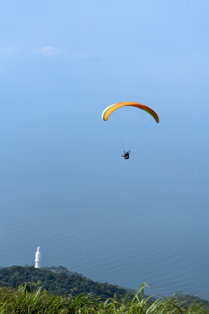 flying paragliding on top of Son Tra Mountain, Vietnam. This is a regular activity of parachute flying clubの写真素材