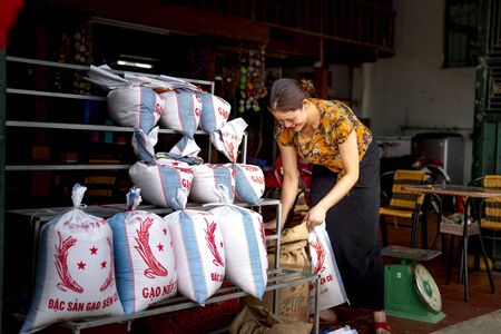 Tu Le, Mu Cang Chai, Yen Bai Province, Vietnam - September 18, 2019: an ethnic woman is preparing new rice for sale. The newly harvested rice is always a popular specialty itemのeditorial素材